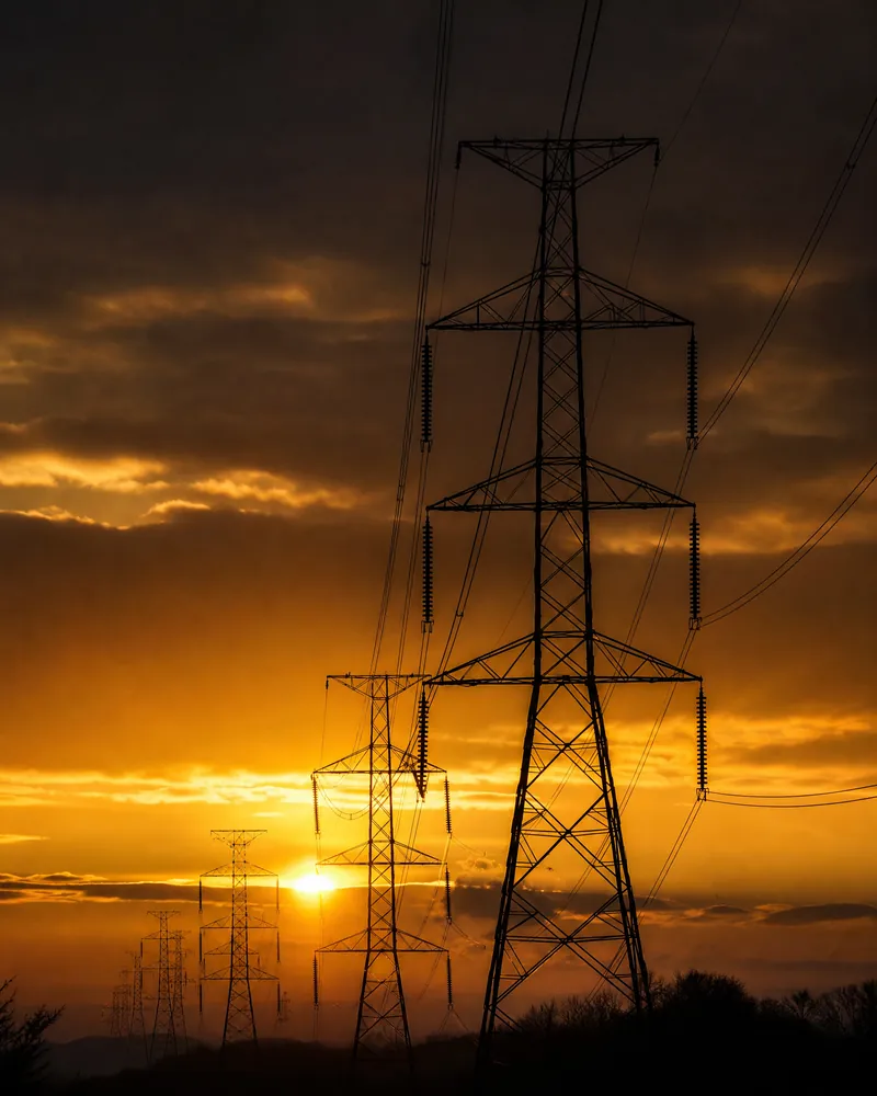 High-voltage transmission towers at sunset